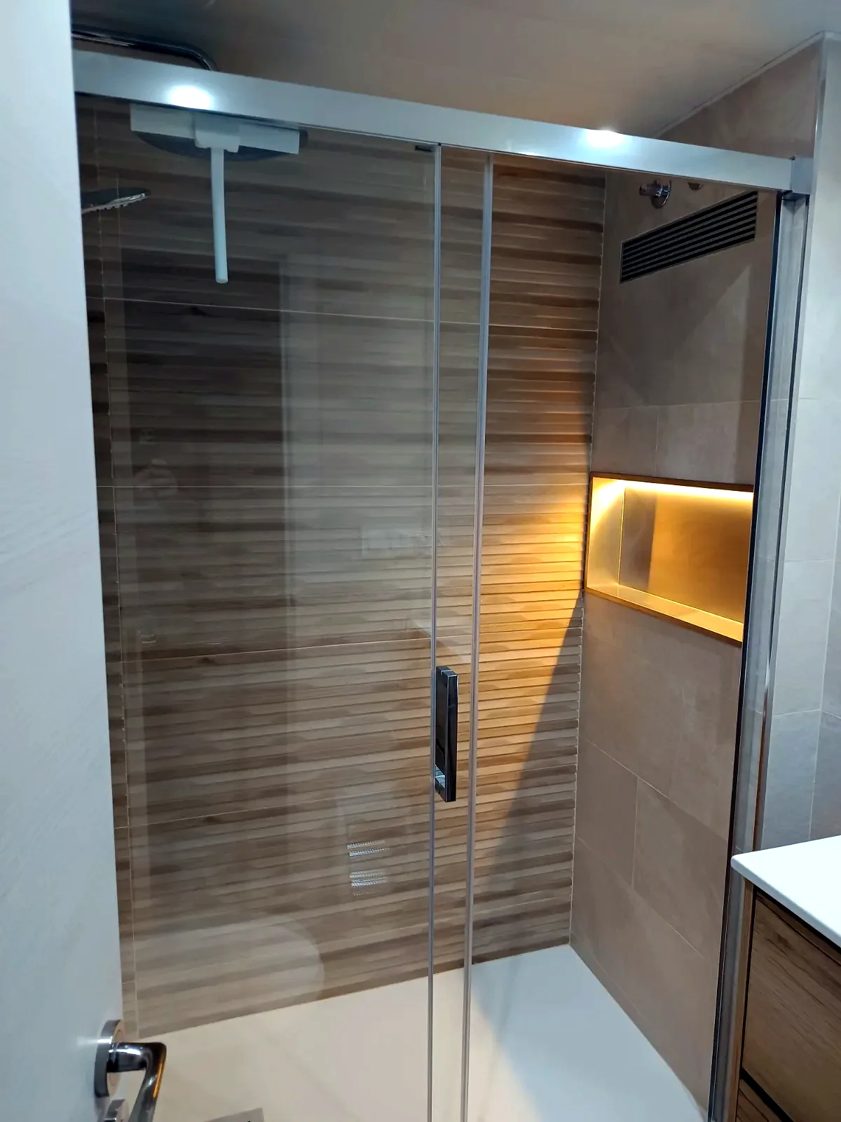 Ducha con mampara corredera y hornacina iluminada